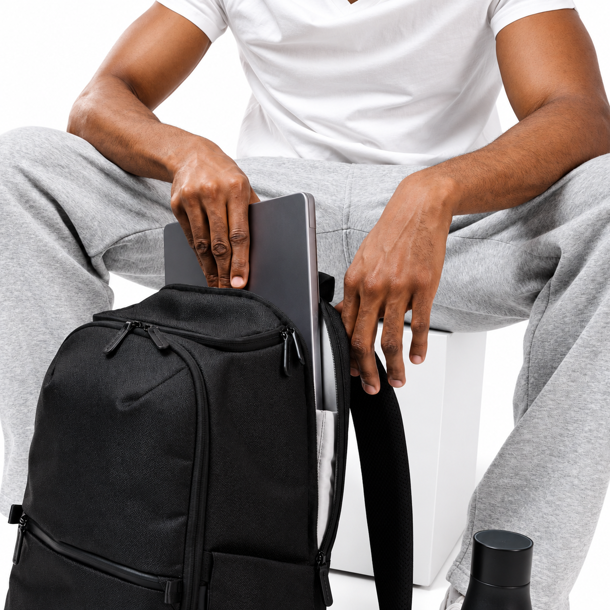 Man sliding a laptop into the padded compartment of the Kuro Switchpack